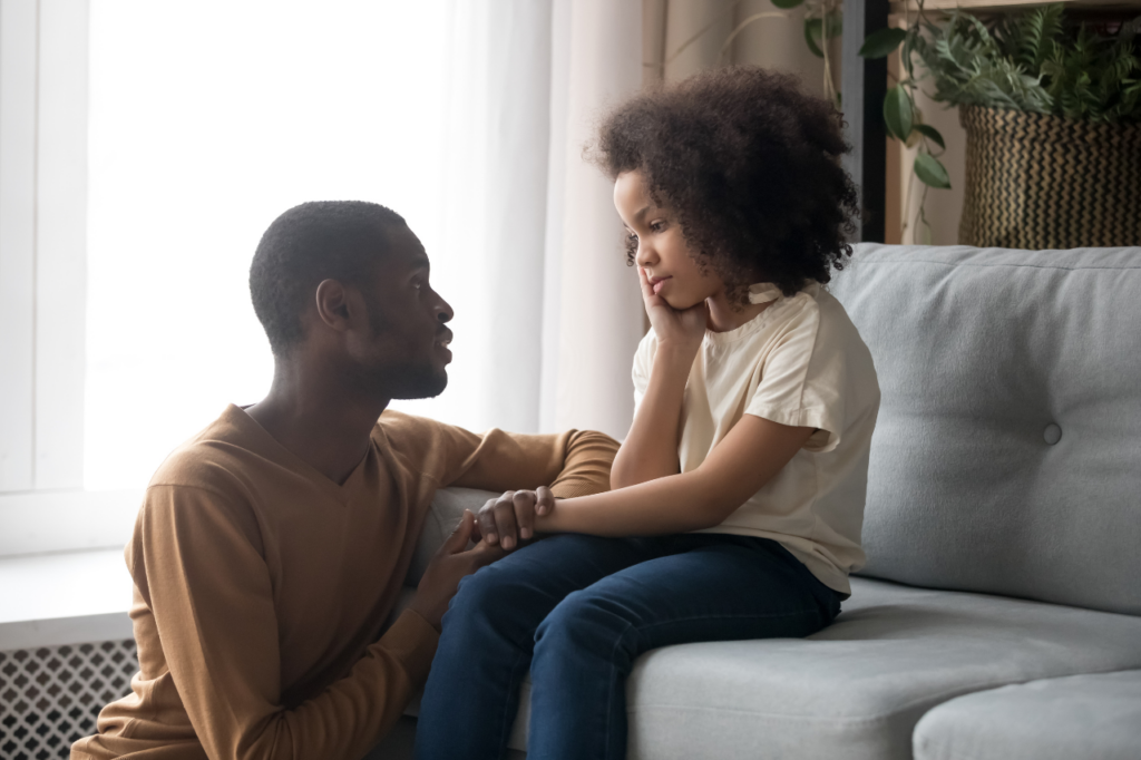 Dad kneeling in front of young child while holding her hand. Gratitude enhances emotional regulation which makes you a better parent.